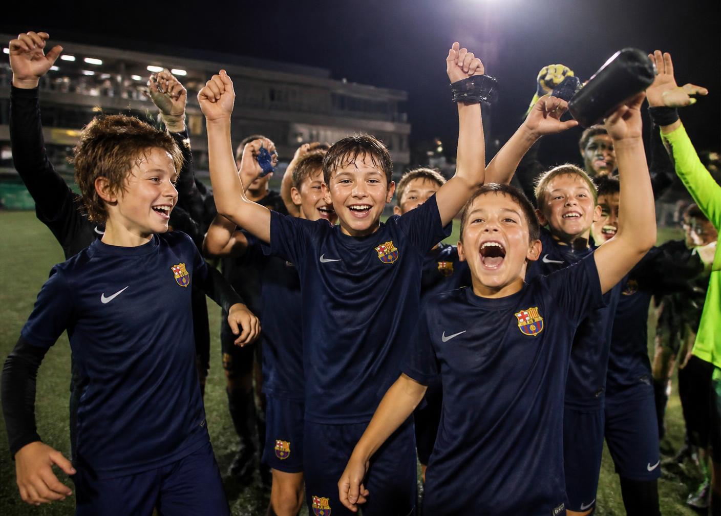 Jeugdvoetbalteam juicht na een overwinning onder de lichtmasten